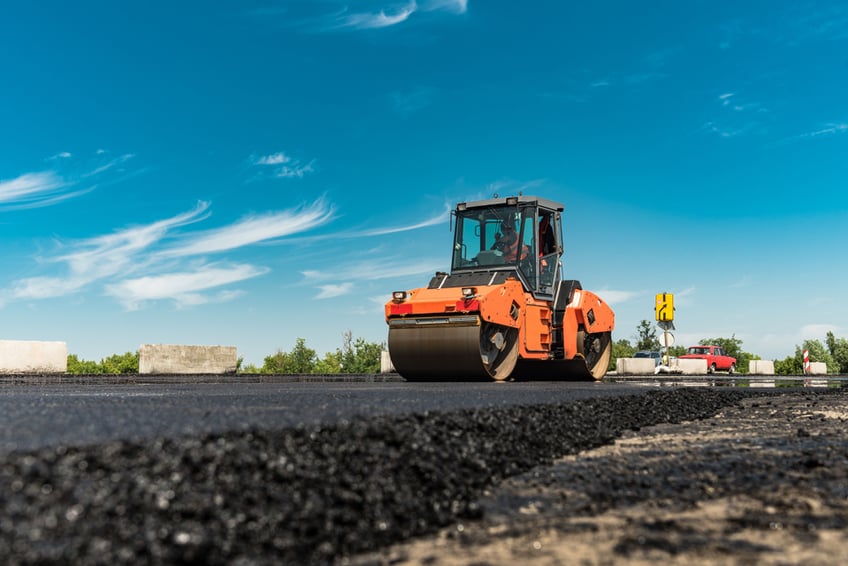 Asphalt rates- Roller rolling fresh hot asphalt on the new road.