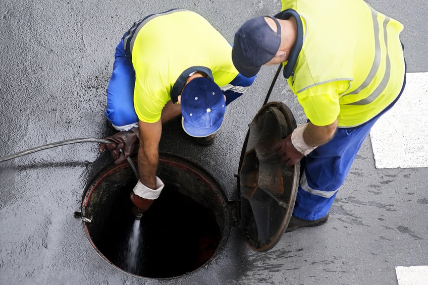 Sewerage workers draining the sewer line
