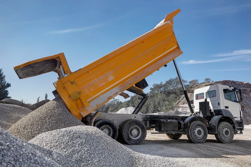 Dump truck tipping aggregate on a construction site