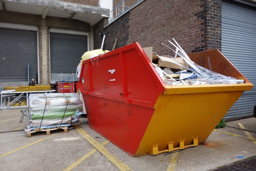 Skip bin filled with debris behind a building