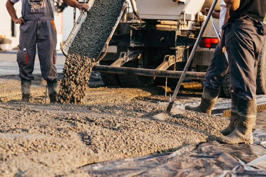 concreters pouring concrete from a concrete truck