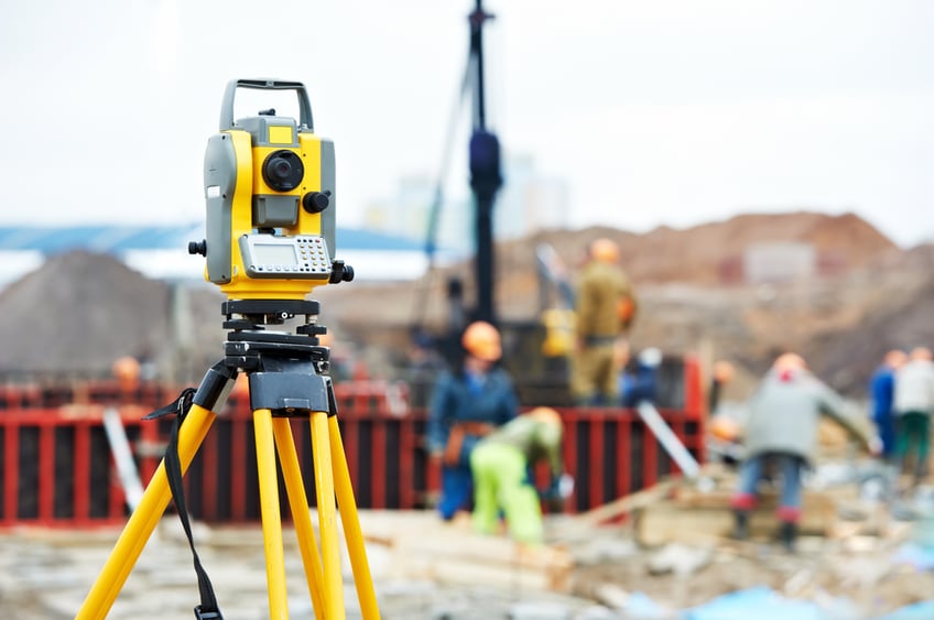 Surveying costs-Surveying measuring equipment theodolite transit on tripod at construction building area site