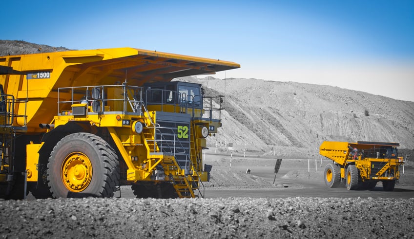 Two large yellow dump trucks used in a modern coal mine in Queensland, Australia