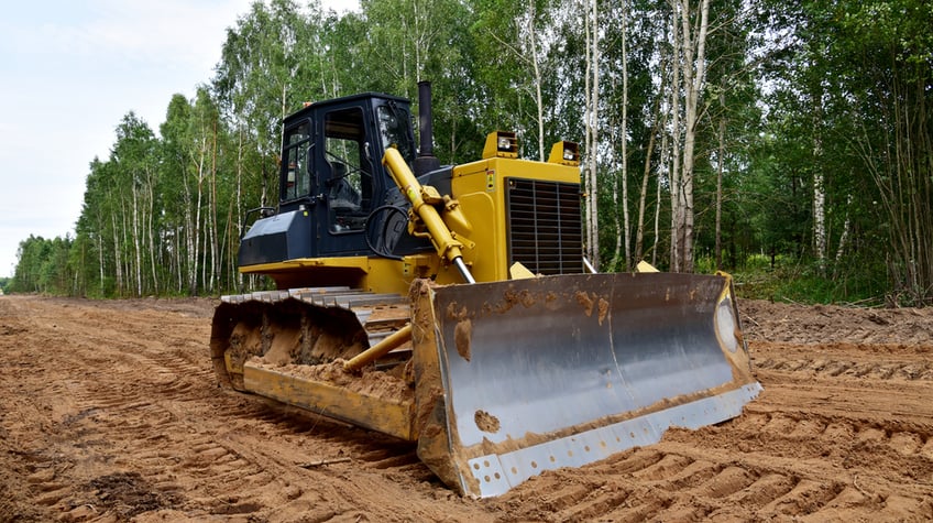 land clearing costs- Dozer during clearing forest for construction new road . Yellow Bulldozer at forestry work Earth-moving equipment at road work, land clearing, grading, pool excavation, utility trenching