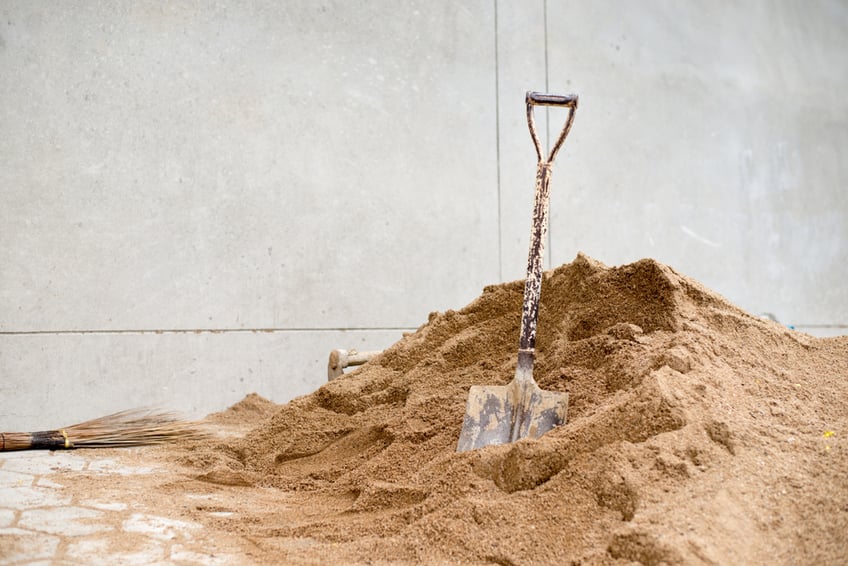 Washed sand in a pile with a shovel in it