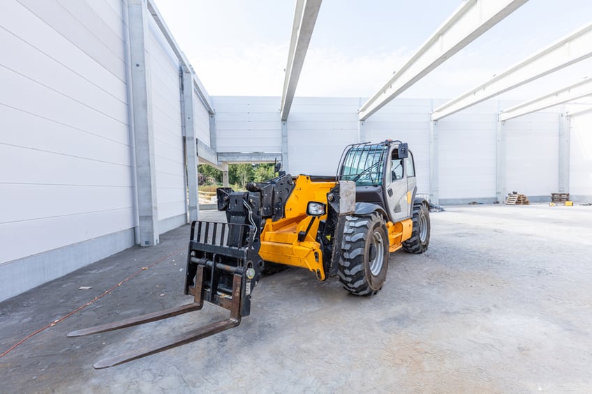 Telehandler in warehouse with fork attachment