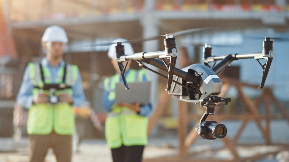 Construction workers operating a drone on a construction site